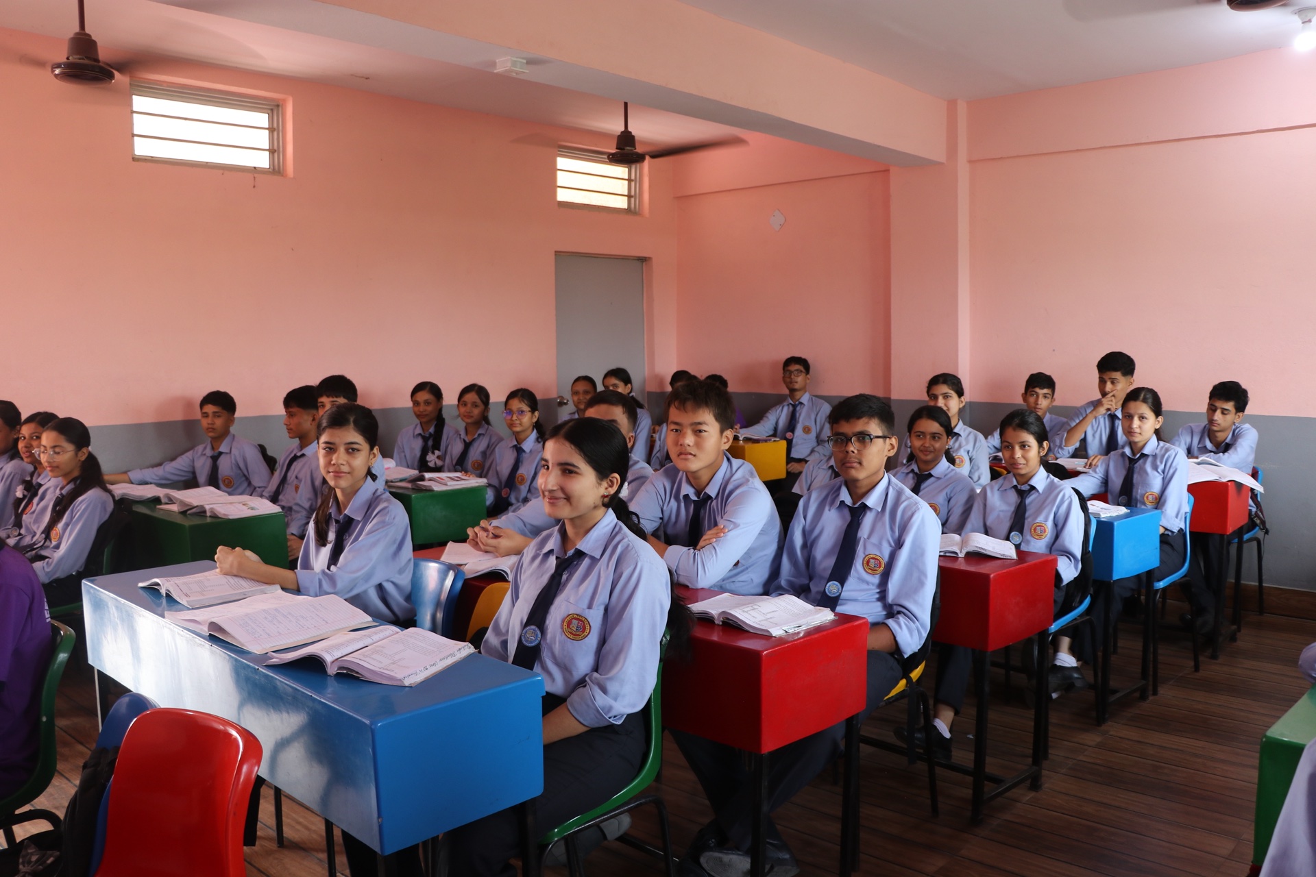 Secondary level students smiling in clean modern classroom