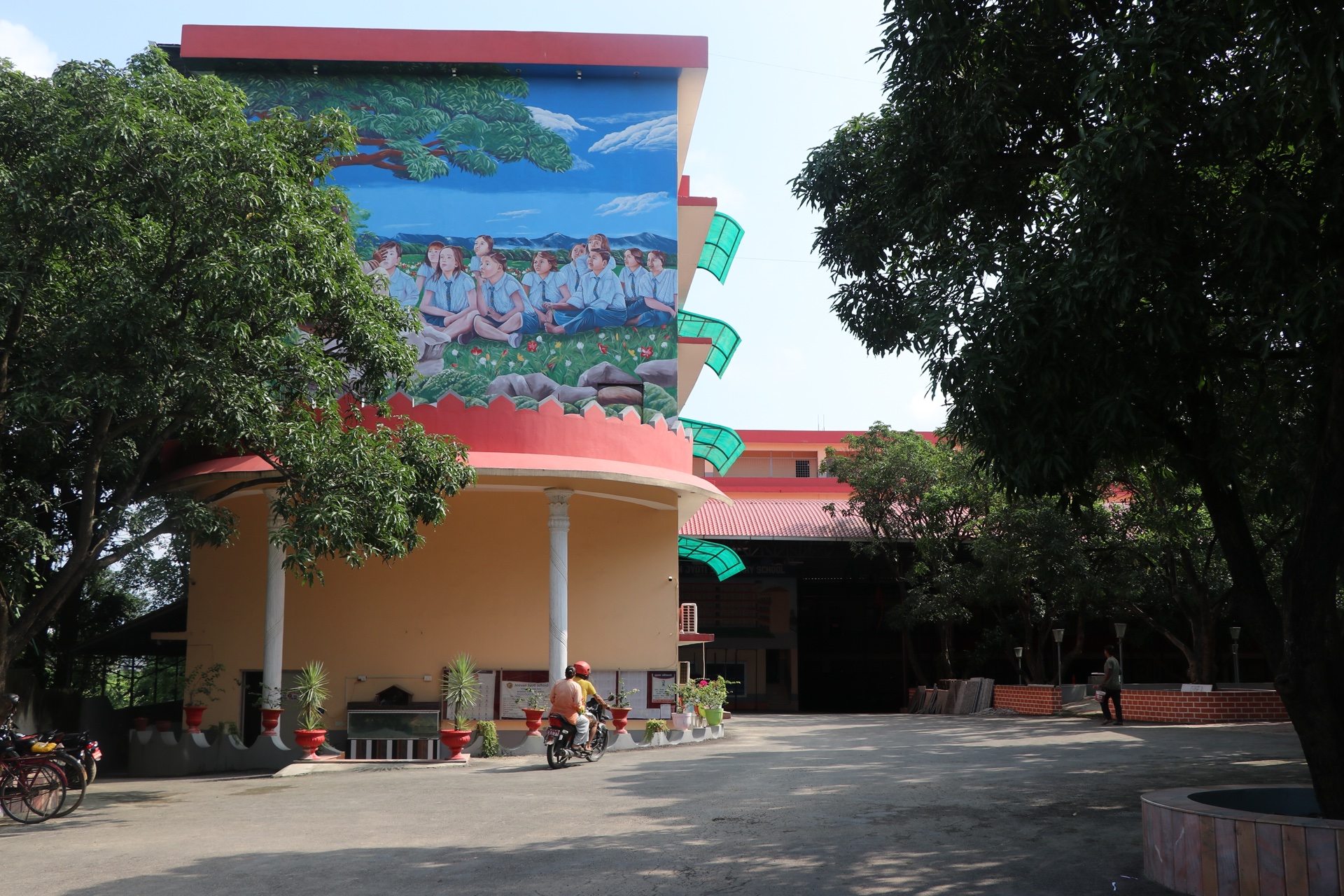 Multistory school building exterior with inspirational artwork mural