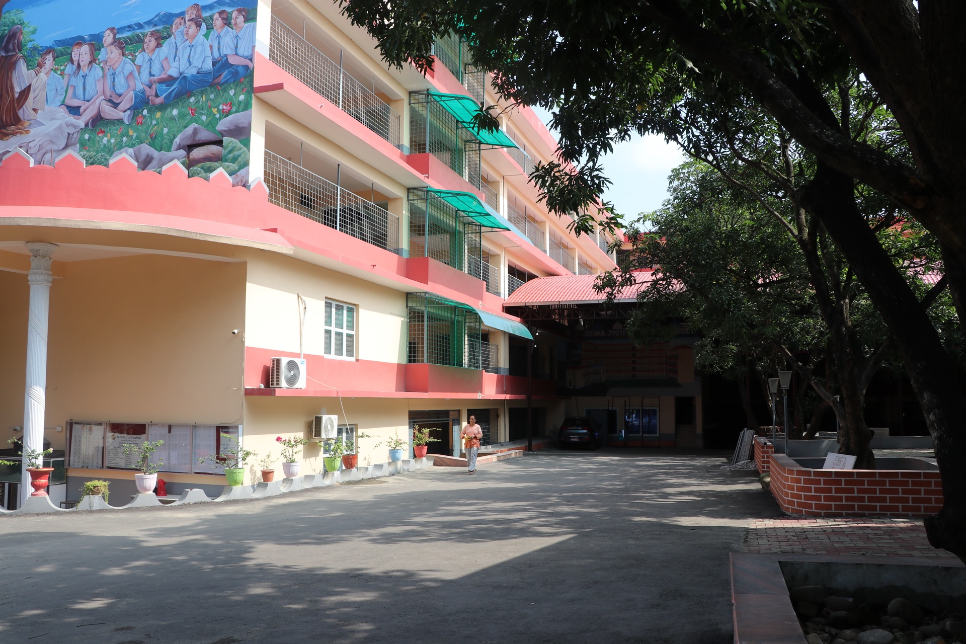 Main academic building wing with shaded paved courtyard