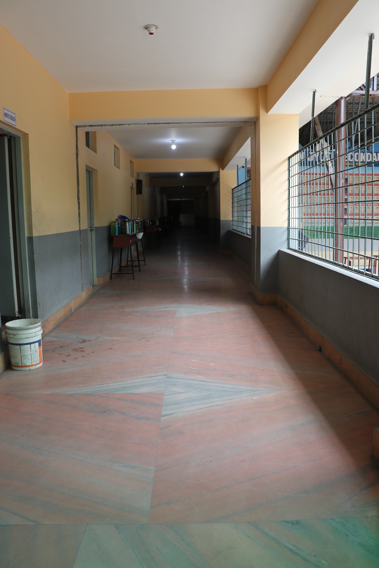 Clean, well-ventilated academic hallway with safety grilles
