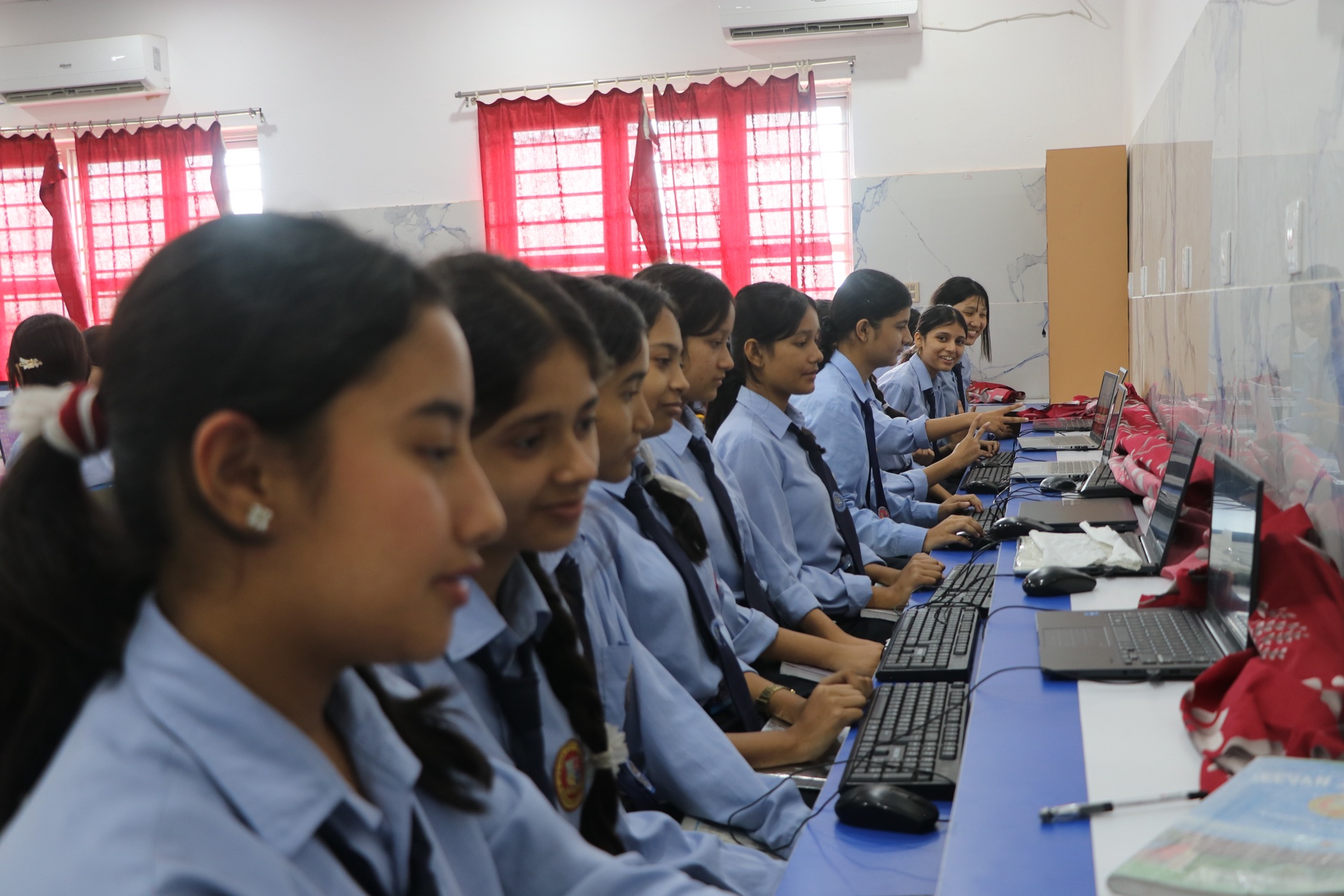 Students learning digital skills on laptops and desktops