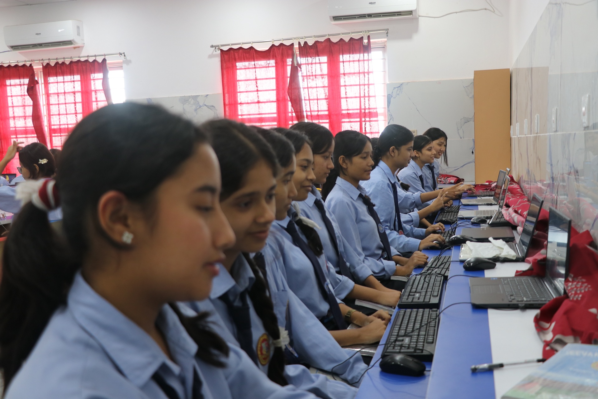 Female students actively practicing coding and digital applications